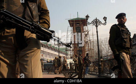 Il 25 gennaio, 2011 - Srinagar Kashmir, India - un poliziotto indiano sta di guardia nella parte anteriore del Kashmir la torre dell orologio nello storico Lal Chowk (quadrato rosso). La sicurezza è stata serrata vicino e intorno alla torre dell orologio come BJP è la pianificazione di issare un Indiano bandiera nazionale presso la torre dell orologio sul giorno della Repubblica celebra Foto Stock