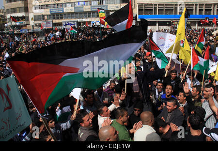 I dimostranti palestinesi tenere bandiere e striscioni durante una manifestazione contro il veto degli Stati Uniti e la chiamata per la riconciliazione nazionale in Cisgiordania città di Nablus, giovedì 24 febbraio, 2011. Foto di Wagdi Eshtayah Foto Stock