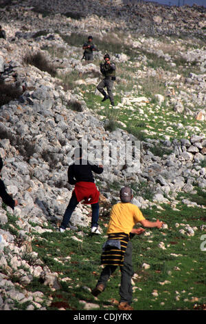 Mar 5, 2011 - Nablus, West Bank, Territori palestinesi - dimostranti palestinesi scagliare pietre contro le truppe israeliane in Cisgiordania villaggio di Iraq Burin, nei pressi di Nablus. (Credito Immagine: &#169; Wagdi Eshtayah/apaimages/ZUMAPRESS.com) Foto Stock