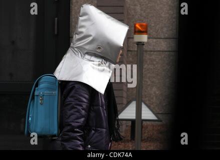 Mar 11, 2011 - Tokyo, Giappone - La scuola i bambini fanno la loro strada di casa indossando un disastro il cofano per proteggere le loro teste. (Credito Immagine: © Jana premere/zReportage.com/ZUMA) Foto Stock