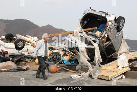 Mar 14, 2011 - Kamaishi, Giappone - uomo cammina davanti a vetture che sono stati portati da tsunami. (Credito Immagine: © Junko Kimura/Jana premere/zReportage.com/ZUMA) Foto Stock