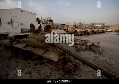 Mar 25, 2011 - Qalat, Provincia di Zabul, Afghanistan - un distrutto serbatoio sovietica riposa accanto a militari statunitensi MRAP (miniera resistente imboscata protetto) i veicoli a motore la piscina a inoltrare una base operativa (FOB) Smart nella capitale provinciale di Qalat nella provincia di Zabul. Con sede centrale a livello FOB Smart, il leader Foto Stock