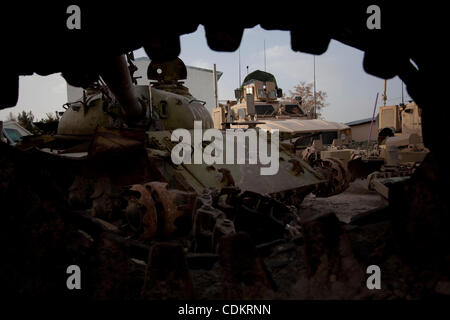 Mar 25, 2011 - Qalat, Provincia di Zabul, Afghanistan - un distrutto serbatoio sovietica riposa accanto a militari statunitensi MRAP (miniera resistente imboscata protetto) i veicoli a motore la piscina a inoltrare una base operativa (FOB) Smart nella capitale provinciale di Qalat nella provincia di Zabul. Con sede centrale a livello FOB Smart, il leader Foto Stock