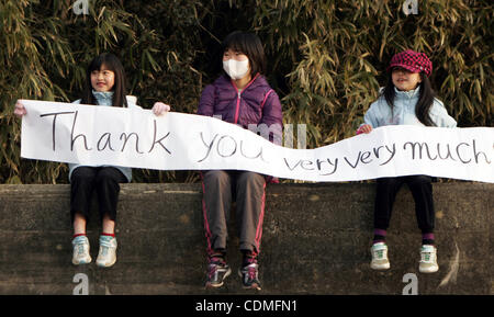 Aprile 7, 2011 - Oshima Isola, Miyagi, Giappone - Due bambini di tenere un banner, ringraziando Marines e marinai del trentunesimo Marine Expeditionary Unit per il loro lavoro. I marines e marinai speso circa sei giorni la pulizia di detriti su parti dell'isola, durante il funzionamento di giorno del Campo. Il trentunesimo meu del coinvolgimento di Foto Stock