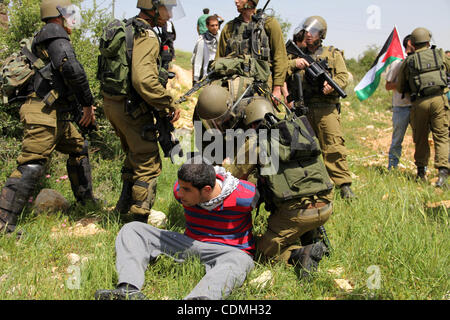 Soldati israeliani detenere un manifestante durante la manifestazione settimanale contro Israele la barriera di separazione in Cisgiordania villaggio di Nabi Saleh, vicino a Ramallah, Venerdì, Aprile 8, 2011. Israele afferma che la barriera è necessario per la sicurezza mentre i palestinesi lo chiamano una terra grab. Foto di STR Foto Stock