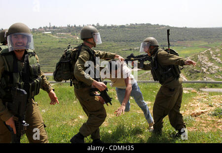 Soldati israeliani detenere un manifestante durante la manifestazione settimanale contro Israele la barriera di separazione in Cisgiordania villaggio di Nabi Saleh, vicino a Ramallah, Venerdì, Aprile 8, 2011. Israele afferma che la barriera è necessario per la sicurezza mentre i palestinesi lo chiamano una terra grab. Foto di STR Foto Stock