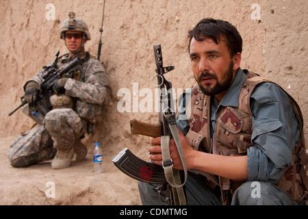 Apr 14, 2011 - quartiere Maywand, Kandahar, Afghanistan - un membro della polizia nazionale afgana tira la sicurezza come privato di prima classe Giacobbe METZ, 30, di Branson, Missouri del 2° plotone, Hawk società del terzo squadrone, 2° Stryker reggimento di cavalleria durante una pattuglia nel villaggio di Tsapowzai in Maywand Foto Stock