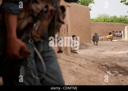 Apr 14, 2011 - quartiere Maywand, Kandahar, Afghanistan - un locale Afghan (centro) orologi un membro della polizia nazionale afgana tirando la sicurezza durante un pattugliamento comune con gli Stati Uniti Forze armate nel villaggio di Tsapowzai nel quartiere Maywand, provincia di Kandahar, Afghanistan. Mentre la sicurezza in Maywand dist Foto Stock