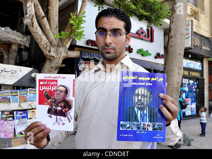 Un egiziano l'uomo guarda i libri e le riviste con un front page foto del deposto leader egiziano Hosni Mubarak il 25 maggio 2011, un giorno dopo il procuratore di Stato ha annunciato che il Presidente Mubarak e i suoi due figli dovrebbero affrontare un processo in un tribunale penale oltre le uccisioni di anti-regime manifestanti e la corruzione. Ph Foto Stock