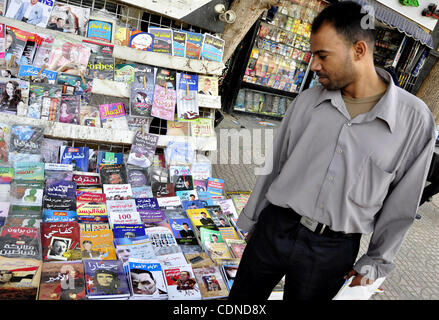 Un egiziano l'uomo guarda i libri e le riviste con un front page foto del deposto leader egiziano Hosni Mubarak il 25 maggio 2011, un giorno dopo il procuratore di Stato ha annunciato che il Presidente Mubarak e i suoi due figli dovrebbero affrontare un processo in un tribunale penale oltre le uccisioni di anti-regime manifestanti e la corruzione. Ph Foto Stock