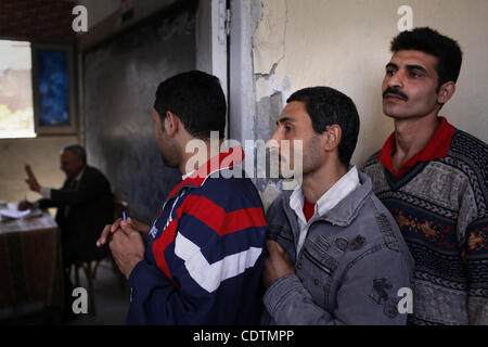 Mar 19, 2011 - Cairo, Egitto - Gli elettori di attendere per immettere la camera voto di una scuola in Manshyet Nasr, prevalentemente cristiana copta quartiere del Cairo. Oggi è stato un importante votare a favore o contro i cambiamenti proposti in Egitto la costituzione. Una parte della discussione su questa votazione ha trasformato in un sectaria Foto Stock