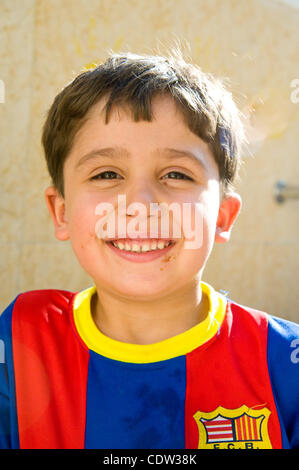 Giugno 25, 2011 - Amman in Giordania - Giugno 25, 2011, Amman, Giordania - un giovane ragazzo sorge da un rubinetto esterno sui terreni della Chiesa latina in Misdar in Amman, Giordania. Egli e le altre comunità cristiane membri aveva raccolto in precedenza per una riunione settimanale organizzata da volontari collegati con la Caritas Vo Foto Stock