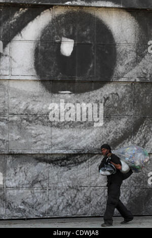 Sett. 14, 2011 - Los Angeles, California, Stati Uniti - un senzatetto uomo cammina davanti a un murale su Alemda St in Los Angeles. Il livello di povertà negli Stati Uniti ha raggiunto ora 15,1% 46,2 milioni di Americani ora vive al di sotto della soglia di povertà; Los Angeles ha la più grande popolazione di persone senza dimora in noi. Arte di strada da Foto Stock