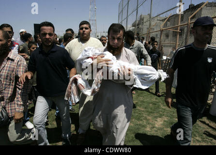 Agosto 19, 2011 - Rafah nella striscia di Gaza - un uomo palestinese porta il corpo di due-anno-vecchio ragazzo Malek Sha'at Durante il suo funerale a Rafah nel sud della striscia di Gaza. Israeli jet fighter ha bombardato la striscia di Gaza, uccidendo un adolescente e il ferimento di altre cinque persone, in rappresaglia per una serie di attacchi coordinati su agosto 1 Foto Stock