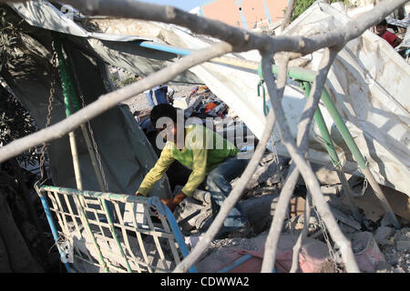 Agosto 19, 2011 - Gaza City, nella Striscia di Gaza - palestinesi in piedi sopra una casa distrutta dopo un attacco aereo israeliano a Gaza City. Aeronautica Israeliana Hamas ha colpito gli impianti di sicurezza a Gaza, uccidendo almeno un palestinese, in ulteriori misure di ritorsione per attacchi lungo il confine egiziano in cui otto Isra Foto Stock