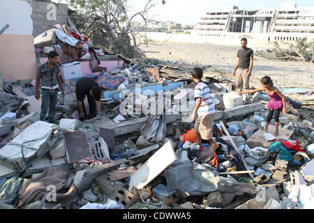 Agosto 19, 2011 - Gaza City, nella Striscia di Gaza - palestinesi in piedi sopra una casa distrutta dopo un attacco aereo israeliano a Gaza City. Aeronautica Israeliana Hamas ha colpito gli impianti di sicurezza a Gaza, uccidendo almeno un palestinese, in ulteriori misure di ritorsione per attacchi lungo il confine egiziano in cui otto Isra Foto Stock