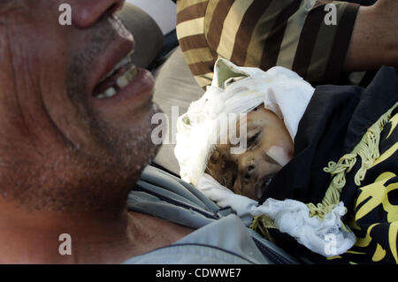 Un uomo palestinese porta il corpo di due-anno-vecchio ragazzo Islam Qreqa durante un funerale di Gaza City il 20 agosto 2011. Palestinesi detto almeno nove militanti sono morti in più israeliani, così come due bambini, uno di loro Islam Qreqa. Foto di Naaman Omar Foto Stock