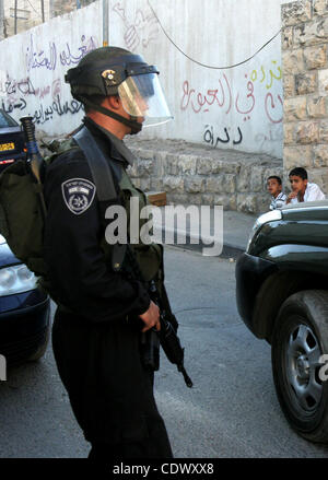 Bambini palestinesi sedersi passato riot israeliano poliziotto di guardia in Gerusalemme est quartiere di Silwan sul set. 13, 2011 seguenti brevi scontri tra polizia e palestinesi tubi espulsori di pietra. Foto di Mahfouz Abu Turk Foto Stock