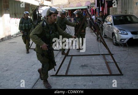 Soldati israeliani vicino alla strada durante una manifestazione contro la chiusura di Shuhada Street a Hebron, la principale arteria bloccata da un militare israeliana checkpoint nel centro della Cisgiordania città di Hebron sett. 14, 2011. I palestinesi hanno dimostrato chiedono libertà di movimento nella loro città come tutte le strade le Foto Stock