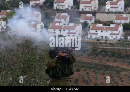 Soldati israeliani fire gas lacrimogeno durante uno scontro con i palestinesi in un settimanale di protesta in Cisgiordania villaggio di Nabi Saleh, vicino a Ramallah Settembre 23, 2011. Forze di sicurezza israeliane sono state in allerme dopo la preghiera del venerdì presso una grande moschea musulmana in Gerusalemme e dintorni territori palestinesi Foto Stock