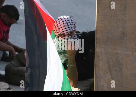 Mascherato giovani palestinesi scontro con le forze israeliane al checkpoint Qalandia tra Gerusalemme e Ramallah il 23 settembre 2011. Alcuni 22.000 polizia israeliana e della polizia di frontiera sono stati su allarme elevato attraverso il paese, pronti a rispondere ad eventuali disordini risultanti da un Palestinese bid per cercare i membri delle Nazioni Unite Foto Stock