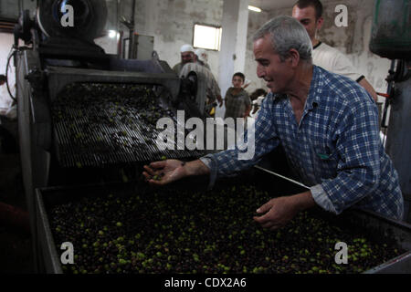 Ottobre 24, 2011 - Ramallah, West Bank, Territorio palestinese - palestinesi la produzione di olio di oliva in fabbrica d'olio d'oliva nella West Bank villaggio di Deir Bezia vicino al West Bank città di Ramallah il 23 ottobre 2011 durante la raccolta delle olive stagione. L' agricoltura è un settore importante della palestinese per la CE Foto Stock