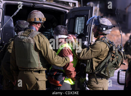 Nov. 12, 2011 - Ramallah, West Bank, Territorio palestinese - soldati israeliani a detenere un cameraman palestinese, Bilal Tamimi, durante gli scontri tra forze di sicurezza israeliane e dimostranti palestinesi a una protesta settimanale in Cisgiordania villaggio di Nabi Saleh, vicino a Ramallah Novembre 11, 2011. Foto Foto Stock