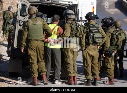 Nov. 12, 2011 - Ramallah, West Bank, Territorio palestinese - soldati israeliani a detenere un cameraman palestinese, Bilal Tamimi, durante gli scontri tra forze di sicurezza israeliane e dimostranti palestinesi a una protesta settimanale in Cisgiordania villaggio di Nabi Saleh, vicino a Ramallah Novembre 11, 2011. Foto Foto Stock