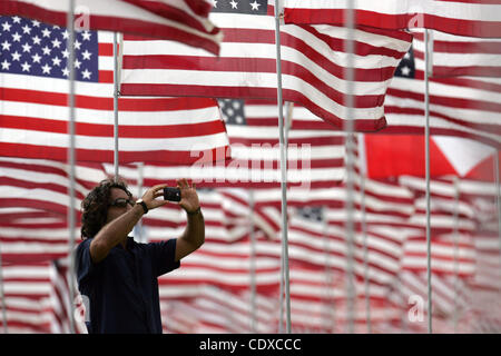 Un uomo fotografie tra tre migliaia di bandierine americane a un monumento in onore delle vittime della sett. 11, 2001 attacchi terroristici, set da volontari sul prato del campus della Università di Pepperdine in Malibu, California il Sabato, Settembre 11, 2011. (Foto di Ringo Chiu / Zuma Press) Foto Stock