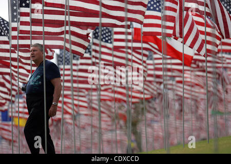Un uomo cammina tra tre migliaia di bandierine americane a un monumento in onore delle vittime della sett. 11, 2001 attacchi terroristici, set da volontari sul prato del campus della Università di Pepperdine in Malibu, California il Sabato, Settembre 11, 2011. (Foto di Ringo Chiu / Zuma Press) Foto Stock