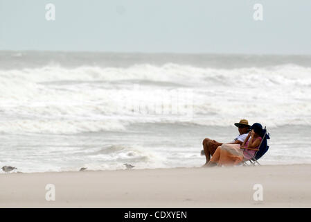 Agosto 25, 2011 - Cocoa Beach, Florida, Stati Uniti - Turisti sedersi tra il vento e le onde agitati fino dall uragano Irene la filatura al largo delle coste della Florida in Cocoa Beach, Florida. (Credito Immagine: &#169; Phelan Ebenhack/ZUMAPRESS.com) Foto Stock