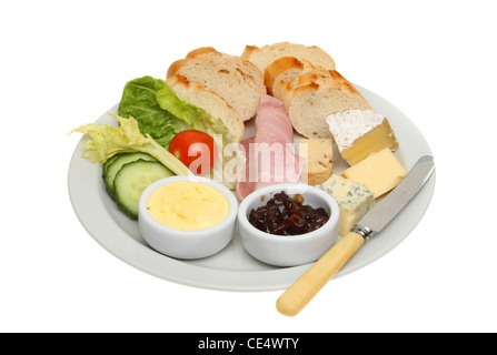 Pranzo Plowmans, pane, formaggio e prosciutto e insalata con burro e pickle su una piastra con un coltello isolata contro bianco Foto Stock