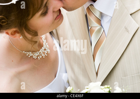 Sposi novelli kissing dopo una cerimonia di matrimonio. Foto Stock