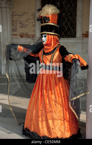 Indossare maschera frequentatori di carnevale sfilano per le strade di Venezia Foto Stock