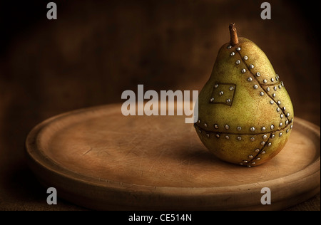 Pera frutta manipolato con chiodi tenendo insieme il concetto per la manipolazione genetica Foto Stock