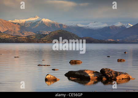 Mattina twilight oltre il lago Wanaka e le vette innevate delle Alpi meridionali, Wanaka, Otago, Nuova Zelanda Foto Stock