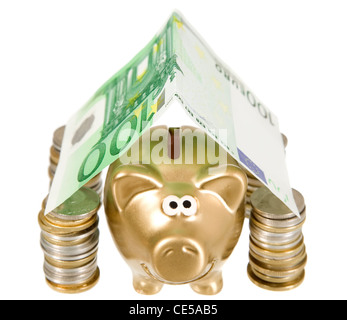 Un golden moneybank sotto le monete banconote ant house Foto Stock