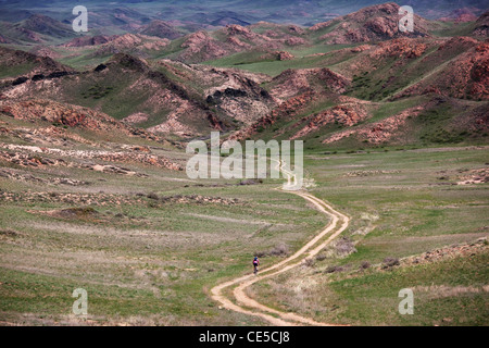 Bikers sulla vecchia strada rurale in montagna nel deserto Foto Stock