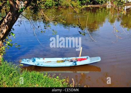 Barca a remi con la riflessione in un stagno Foto Stock