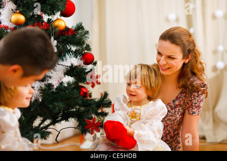 Famiglia di trascorrere del tempo nei pressi di albero di Natale Foto Stock