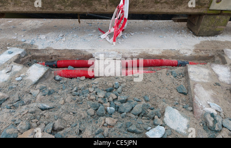 Rosso cavi di potenza furono sepolti in strada Foto Stock