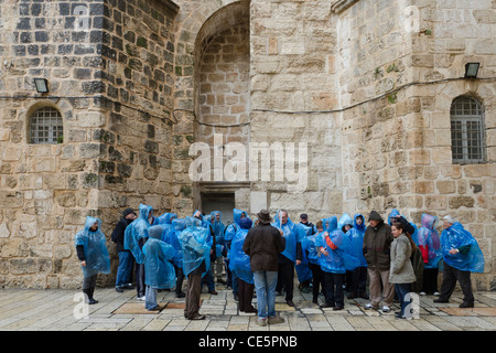 Pellegrini in plastica leggera copertura di pioggia sulla spianata del Santo Sepolcro. Gerusalemme vecchia città. Israele Foto Stock