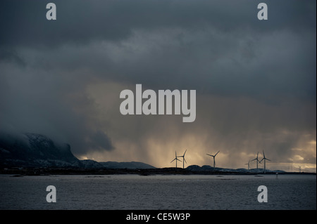 Una turbina eolica azienda sotto una tempesta cielo osservato da una crociera Hurtigruten barca. Norvegia settentrionale Foto Stock