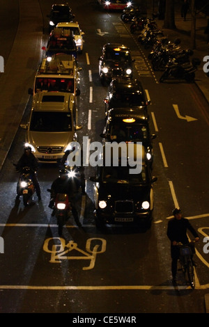 Guardando verso il basso su una coda di traffico in attesa ad un semaforo a Londra per una notte Foto Stock