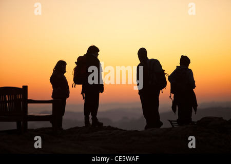 Un gruppo di bambini in età scolare su Orrest testa sopra Windermere al tramonto, nel distretto del lago, UK. Foto Stock