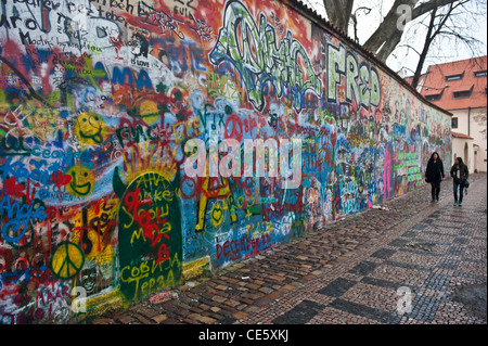 La gente a piedi nella parte anteriore del John Lennon tribute parete in Mala Strana di Praga, Repubblica Ceca Foto Stock