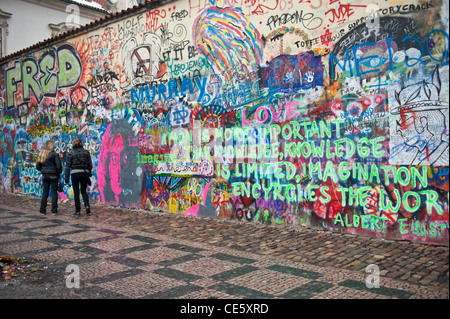 La gente a piedi nella parte anteriore del John Lennon tribute parete in Mala Strana di Praga, Repubblica Ceca Foto Stock