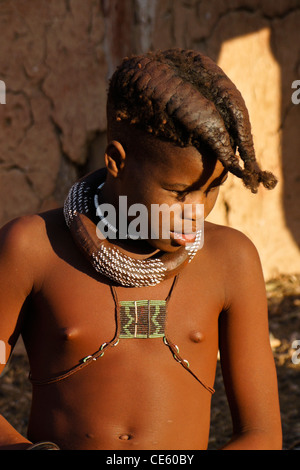 Himba ragazza con i capelli intrecciati in un villaggio vicino a Opuwo, Namibia Foto Stock