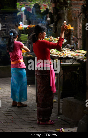 Donna Balinese rendendo offerte indù a un tempio in Ubud Bali Indonesia Foto Stock