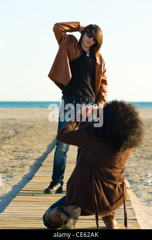 Donna prendendo fotografie di un adolescente sulla spiaggia Foto Stock